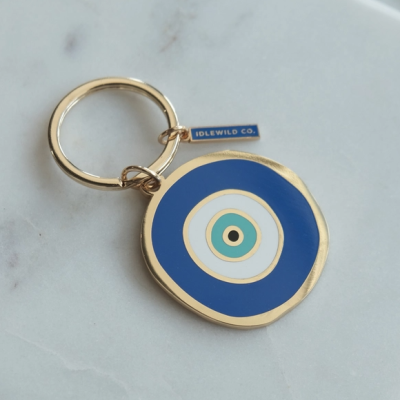 Porta-chaves redondo com padrão de olho turco em azul e dourado com etiqueta IDLEWILD CO.