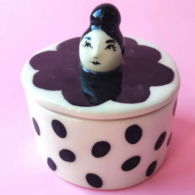 Caixa de cerâmica branca com bolinhas pretas e tampa com figura humana decorativa