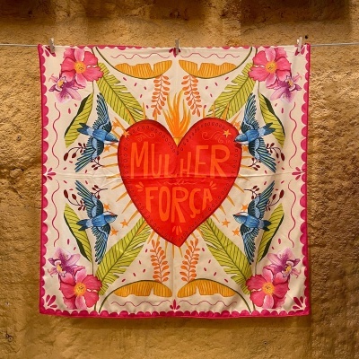 Lenço quadrado com padrão colorido e frase 'MULHER FORÇA' no coração vermelho central