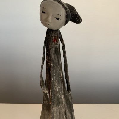 Estátua decorativa feminina de madeira pintada com textura rústica e acabamentos em cinza, preto, branco e vermelho.