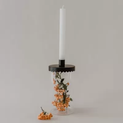 Castical de vidro transparente com vela branca e decoração com bagas cor de laranja