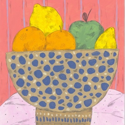 Tigela decorativa com padrão azul contendo laranjas, limas e maçã, sobre tecido rosa e parede rosa.