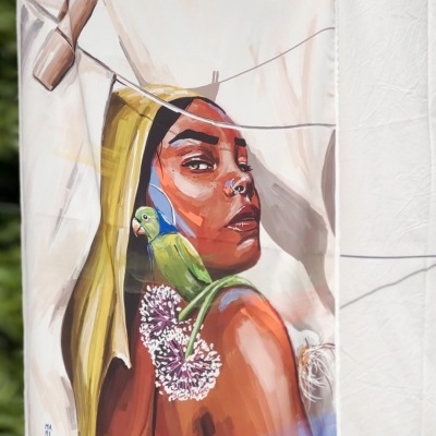 Toalha ou tecido com ilustração feminina e papagaio pendurada ao ar livre