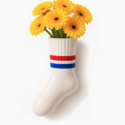 Vaso de cerâmica em forma de meia com flores amarelas