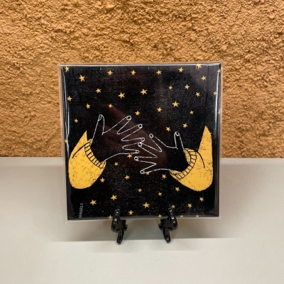 Quadro decorativo com mãos desenhadas e estrelas amarelas