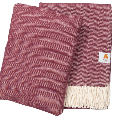 Colcha ou manta vermelha com padrão espinha de peixe e franjas brancas