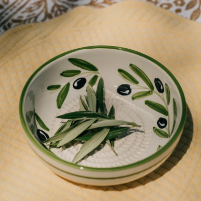 Prato branco decorado com desenho de folhas verdes e azeitonas pretas