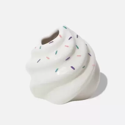 Vaso decorativo em forma de creme chantilly branco com confetis coloridos.