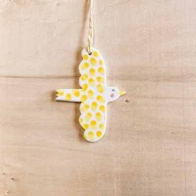 Pendurador decorativo em forma de passarinho amarelo com manchas redondas