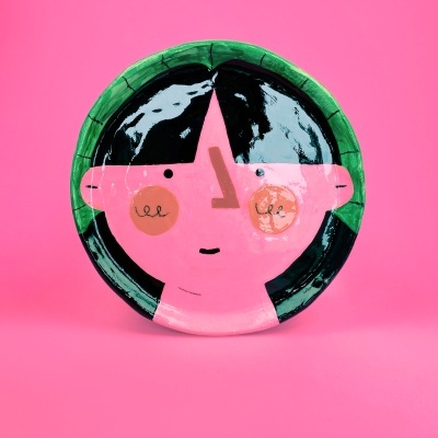 Prato cerâmico decorativo com rosto pintado em rosa, verde e preto