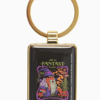 Chaveiro dourado com imagem de mago, plantas e texto Off In FANTASY Land