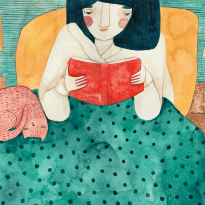 Mulher lê livro vermelho na cama com colcha verde, gato rosa, candeeiros amarelos e mesa de cabeceira de madeira