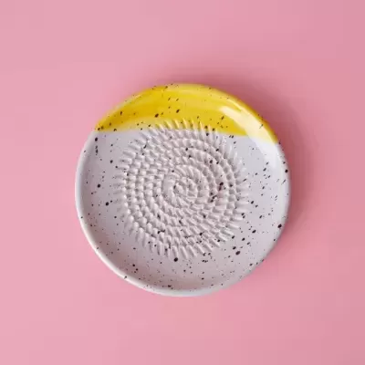 Prato redondo cerâmico com padrão salpicado e textura circular