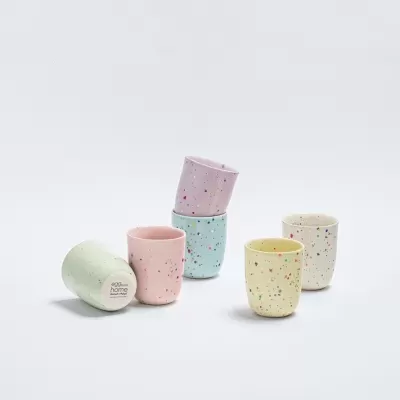 Conjunto de seis copos pequenos coloridos com manchas sobre fundo branco.