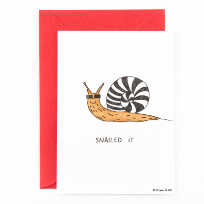 Cartão branco com desenho de caracol e texto 'SNAILED IT' com envelope vermelho