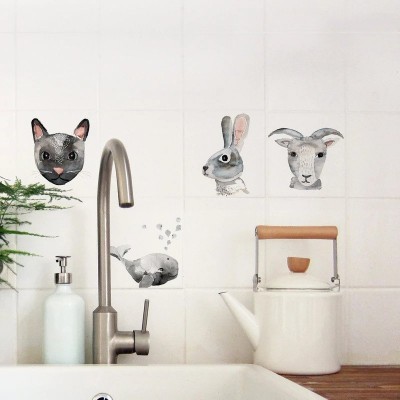 Cozinha com torneira metálica, dispensador de sabão branco, chaleira branca com alça de madeira, planta e autocolantes de animais na parede.