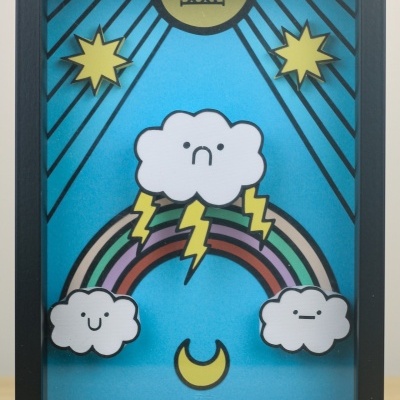 Quadro decorativo com nuvens, arco-íris, sol, estrelas e lua em fundo azul
