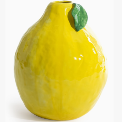 Vaso cerâmico amarelo em forma de limão com folha verde