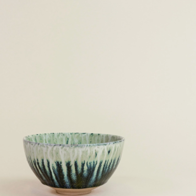 Tigela de cerâmica verde e preta com padrão escorrido