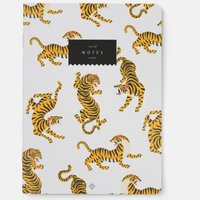 Caderno branco com padrão de tigres amarelos e pretos e etiqueta preta com texto 'wild NOTES'