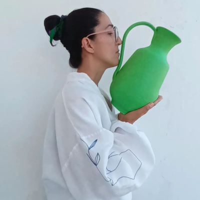 Mulher segurando jarro verde grande