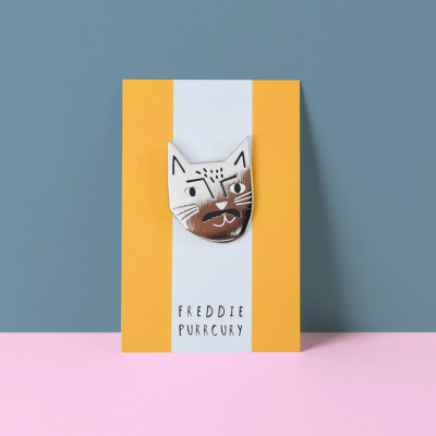 Broche gato pintado sobre cartolina com texto FREDDIE PURRCURY