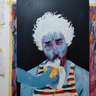Quadro pintado de uma pessoa a comer uma banana com roupa às riscas, numa parede com outras pinturas e notas coladas