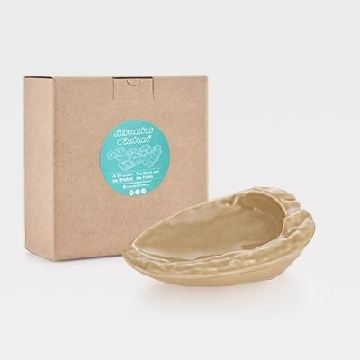 Recipiente de cerâmica bege em forma de noz com caixa de papelão castanho e etiqueta azul