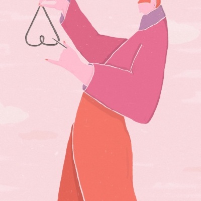 Pessoa segurando cabide em forma de coração com roupa colorida em fundo rosa