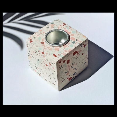 Castiçal cúbico em material terrazzo com suporte metálico circular no topo
