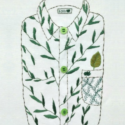 Desenho bordado de camisa branca com folhas verdes e botões verdes