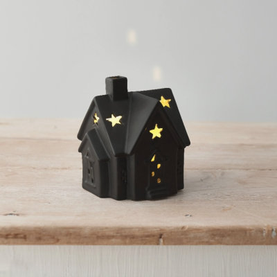 Miniatura preta casa cerâmica com luz interior e recortes estrelas