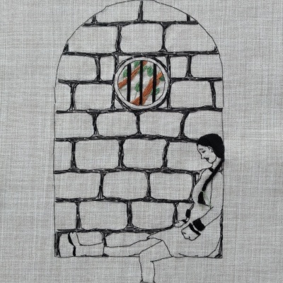 Desenho bordado de pessoa sentada junto a parede de pedra com janela circular
