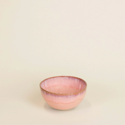 Taça de cerâmica rosa com borda castanha sobre fundo bege