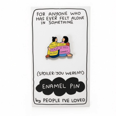 Pin de esmalte com duas pessoas abraçadas em cartão branco com texto em inglês