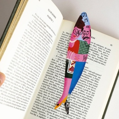 Marcador de páginas colorido em forma de garrafa de vinho num livro aberto em português