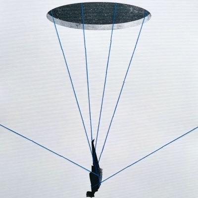 Silhueta pendurada numa rede circular preta com cordas azuis em fundo branco.