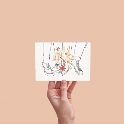 Desenho de ténis com flores em fundo bege segurado por mão