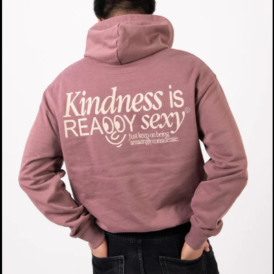 Pessoa de costas a usar sweatshirt rosa antigo com texto em branco na parte de trás.