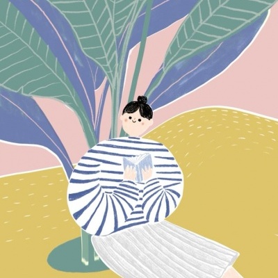 Pessoa vestida com camisola riscada e saia branca lendo livro junto a planta grande