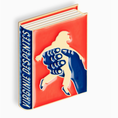 Livro vermelho com lombada azul e texto VIRGÍNIA DESPENTES, capa com mão azul segurando figura humana branca