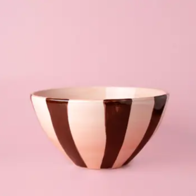 Taça de cerâmica creme com riscas castanhas em fundo rosa