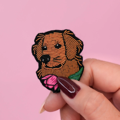 Patch bordado em forma de cabeça de cão castanho com flor rosa
