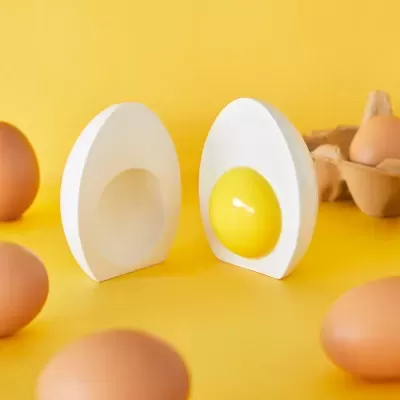 Saleiro e pimenteiro em forma de ovo partido com fundo amarelo