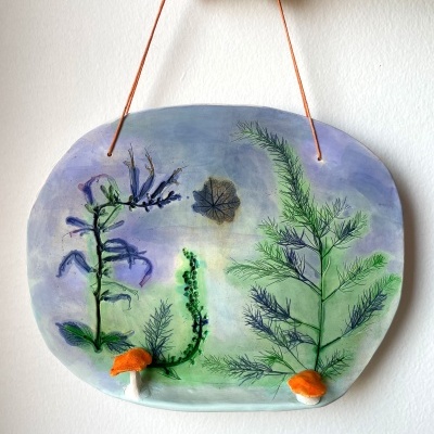 Placa decorativa oval com pintura botânica e cogumelos laranja pendurada na parede