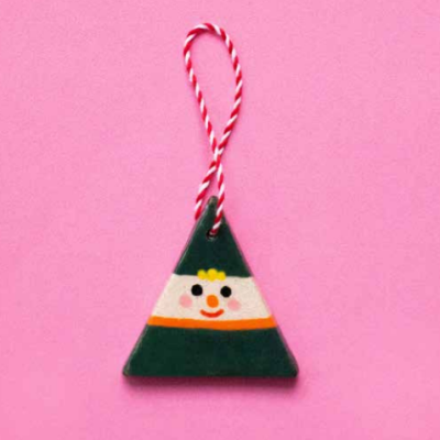 Pendente triangular de cerâmica com rosto sorridente e cordão vermelho e branco