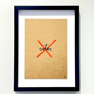 Quadro com moldura preta com impressão de 'X' vermelho e palavra 'votar' numa parede branca