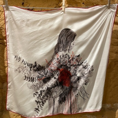 Tecido com ilustração artística de mulher a segurar um grande ramo de flores em preto, cinza e vermelho, com contorno vermelho e assinatura MIRTA NUNES.