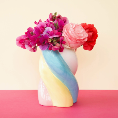 Vaso cerâmico colorido com flores naturais em tons de rosa, vermelho e violeta