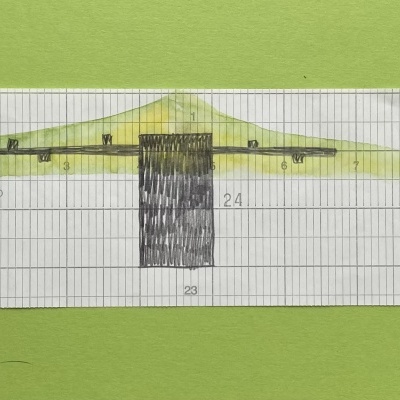 Régua plástica transparente com marcações amarelas e pretas sobre fundo verde